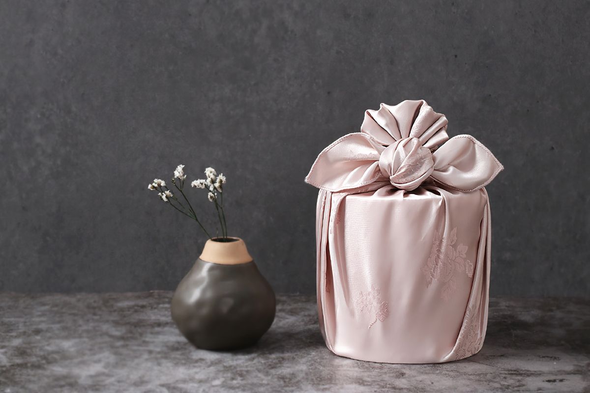 round boxe wrapped with light pink color Bojagi.