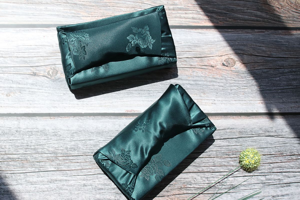 two rectangular boxes wrapped with blue green color Bojagi.